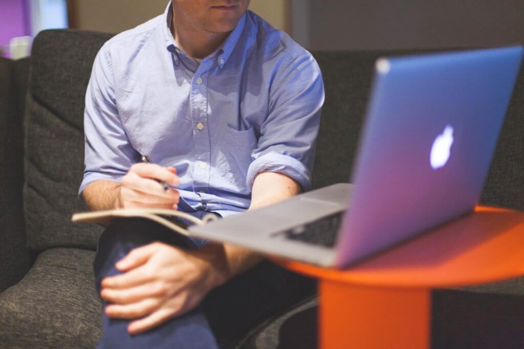 Man sitting in front of his laptop doing a full risk mitigation of his project