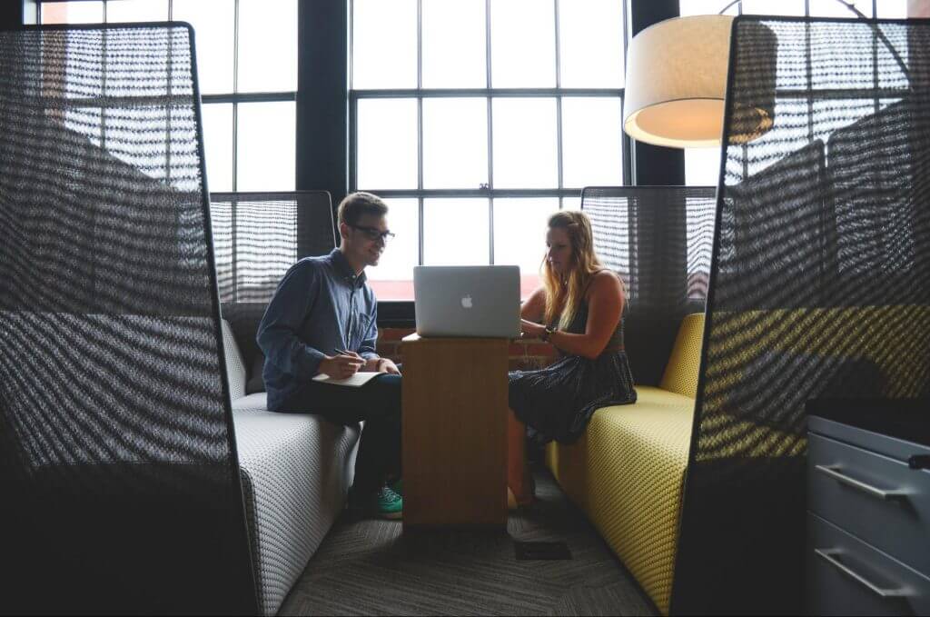 Woman and man sitting in front of computer brainstorming ideas for a risk evaluation