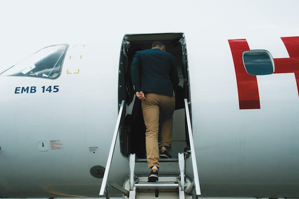 A picture of a man getting onto a plane, which represents a new hire employee being onboarded into a new organization